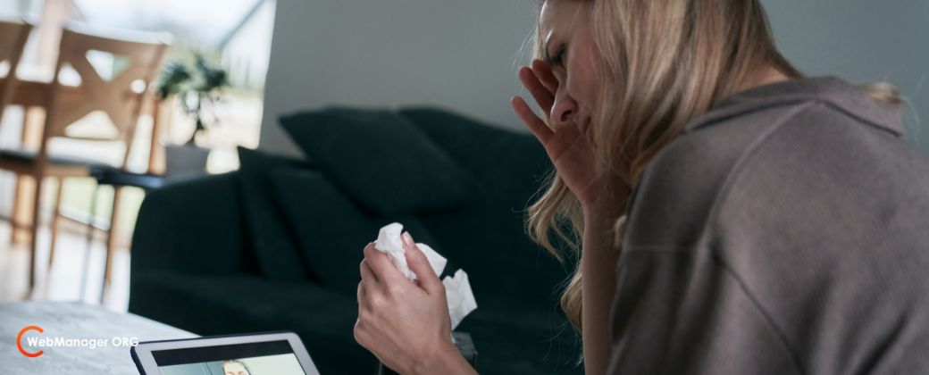 רואים את אחורי הגוף של אישה אשר עוברת טיפול רגשי אונליין מול צג דיגיטלי ובצד שמאל למטה לוגו אתר webmanager